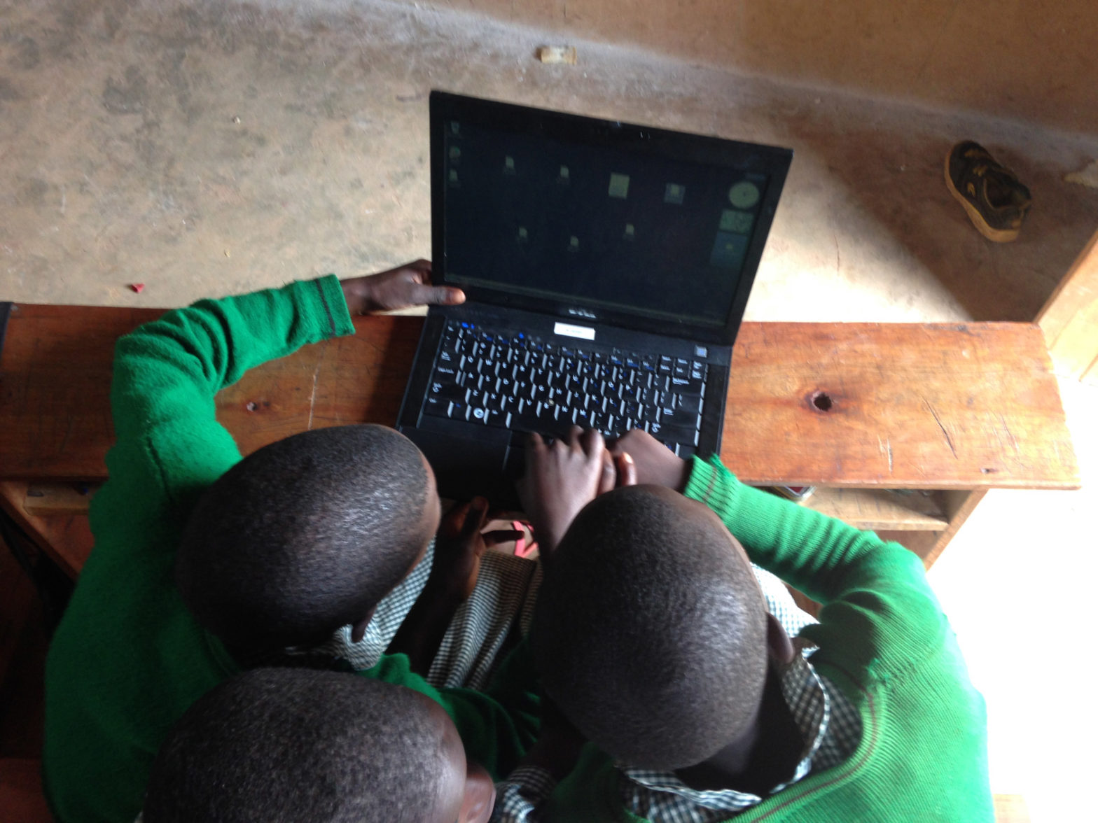 Photo of students in Uganda working on a CMC donated laptop