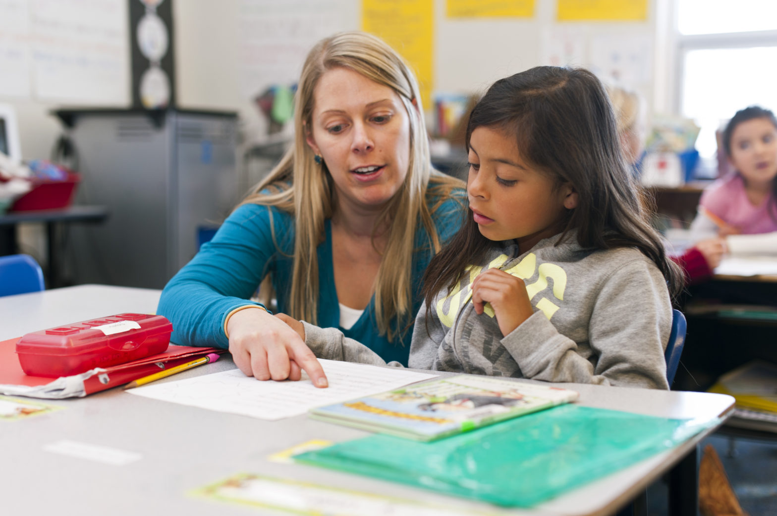 Photo of young woman teaching young latina girl in Basalt Elementary school