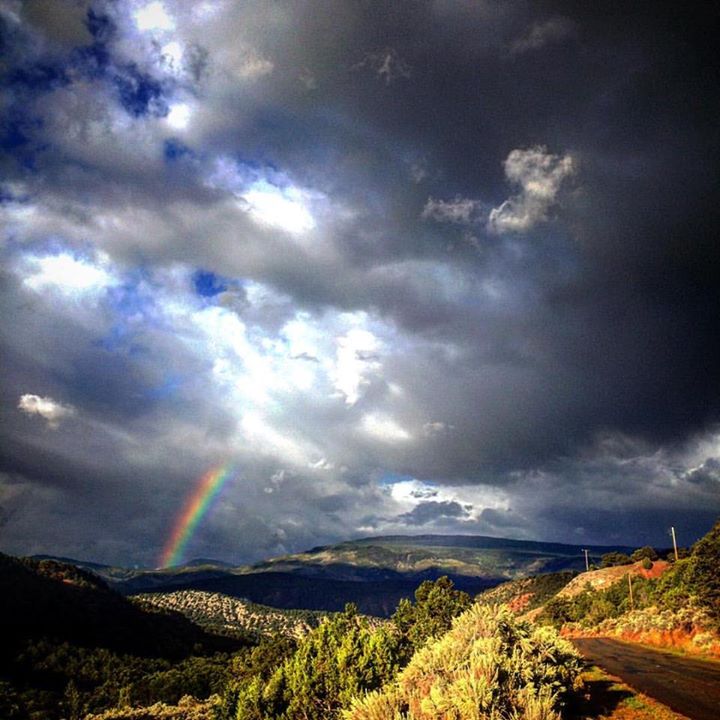 Photo of rainbow and dark morning clouds over Cattle Creek Road, Carbondale