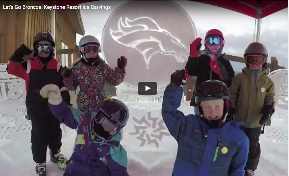 Still capture of kids next to an ice sculpture honoring the Denvrer Broncos on top of Keystone mountain