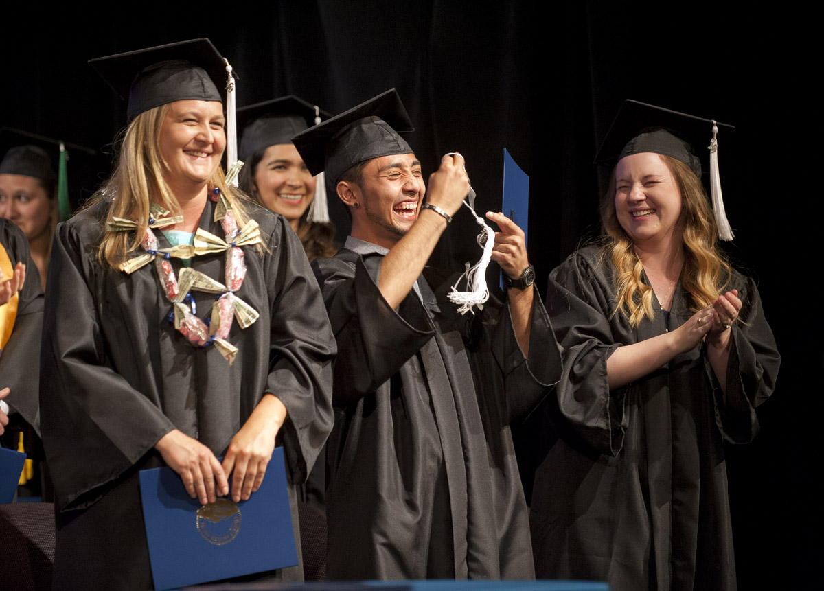 Photo of CMC Bachelor of science business administration graduates, from left, Elizabeth Raymond, Kevin Nakagawa and Kayli Danyell Pace have a laugh after Nakagawa rips his tassel completely from his mortar board at the ceremonial turning of the tassels portion of the bachelor’s commencement ceremony on May 6 at Colorado Mountain College’s campus in Spring Valley.