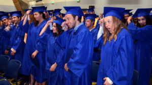 Photo of Colorado Mountain College students take part in the time-honored tradition of moving their tassels from right to left near the end of the May 7 graduation ceremony at Spring Valley on May 7