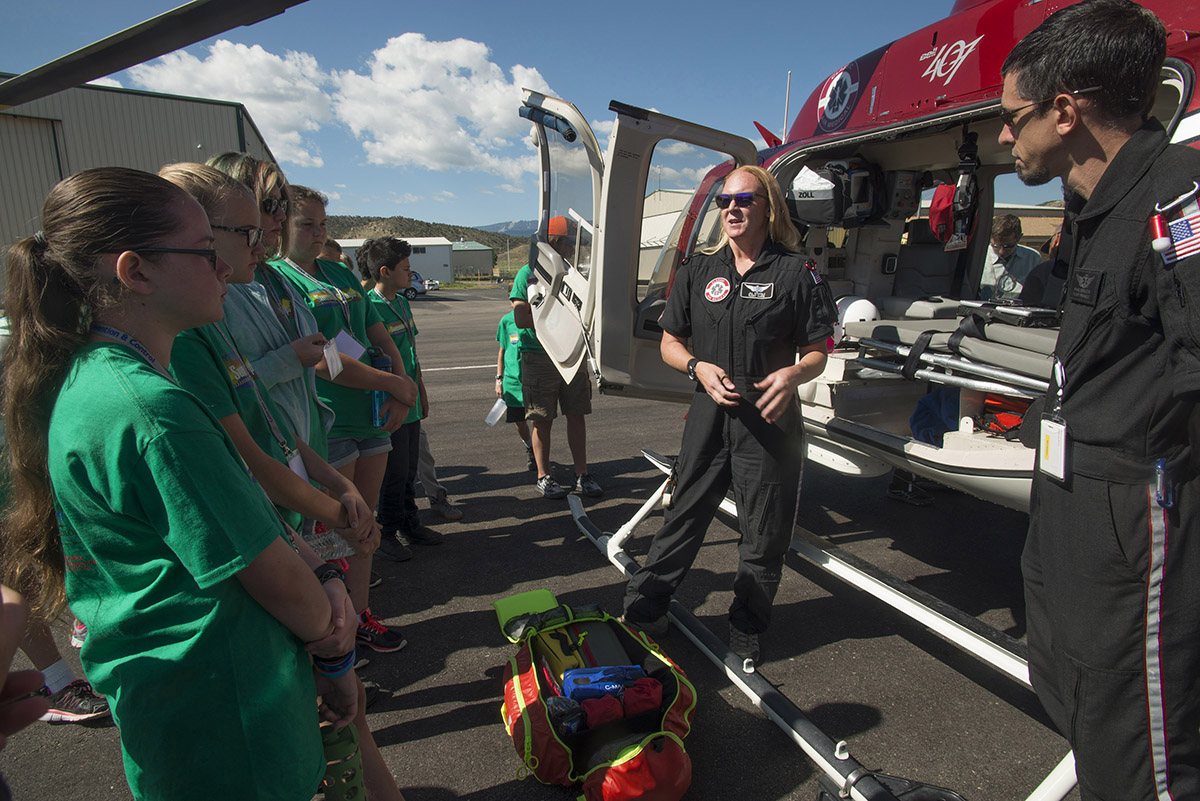 Reach Your Peak campers stand on the Rifle Airport tarmac while listening to flight nurse Jill Stoffels explain how she and her fellow helicopter crew members prepare for emergency medical runs. Photo Kate Lapides